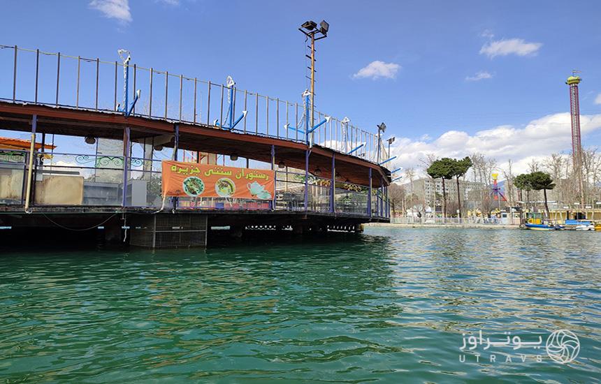 دریاچه پارک ارم که فضایی اسکله‌مانند وسط آن قرار دارد و یک با متن «رستوران سنتی جزیره» روی دیواره‌اش نصب شده‌است.